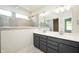Bathroom featuring a large mirror over dual sinks, gray cabinets, tile floors, and a bathtub at 14383 Coyote Ridge Dr, Noblesville, IN 46060