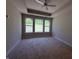 Bright bedroom with neutral carpet, a ceiling fan, tray ceiling and three large windows offering backyard views at 14383 Coyote Ridge Dr, Noblesville, IN 46060
