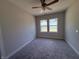 Bedroom with neutral carpet, a ceiling fan, and two windows offering neighborhood views at 14383 Coyote Ridge Dr, Noblesville, IN 46060