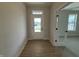 Bright entryway with wood-look floors, transom window, and glass-paned doors leading to other rooms at 14383 Coyote Ridge Dr, Noblesville, IN 46060