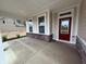 Inviting front porch with stone accents, neutral siding, and a red front door entrance at 14383 Coyote Ridge Dr, Noblesville, IN 46060