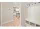 Hallway with coat hooks, built-in bench and a view into the open kitchen with white cabinets and stainless steel appliances at 14383 Coyote Ridge Dr, Noblesville, IN 46060
