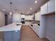 Spacious kitchen with island, stainless steel appliances, white cabinets, and stylish pendant lighting at 14383 Coyote Ridge Dr, Noblesville, IN 46060