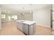 Kitchen island with stainless steel sink, quartz countertop, dishwasher, and view to the living room at 14383 Coyote Ridge Dr, Noblesville, IN 46060