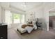 Well-decorated bedroom featuring large windows, trey ceilings, an upholstered bed, and a bathroom entrance at 14383 Coyote Ridge Dr, Noblesville, IN 46060