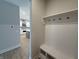 Bright mudroom features a built-in bench, shelf, and hooks, offering practical storage and organization near kitchen at 14383 Coyote Ridge Dr, Noblesville, IN 46060