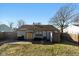 View of home's back exterior with yellow door and large lawn at 1459 E Lynn Dr, Indianapolis, IN 46202