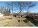 Large backyard featuring mature trees, patio furniture and a wooden fence for privacy at 1459 E Lynn Dr, Indianapolis, IN 46202