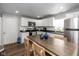 Well-lit kitchen with white cabinets, stainless steel appliances, and a central dining table at 1459 E Lynn Dr, Indianapolis, IN 46202