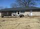 Rear exterior view featuring a covered patio, stone facade, and spacious lawn at 1459 S Josephine St, Martinsville, IN 46151