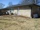 View of the side of a single story house with stone veneer and a backyard area with patio furniture at 1459 S Josephine St, Martinsville, IN 46151