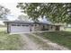 A stone ranch-style home with an attached garage, a stone facade, and mature landscaping at 1459 S Josephine St, Martinsville, IN 46151