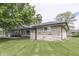 The house has stone siding and a chimney, with a large grassy yard extending to the side at 1459 S Josephine St, Martinsville, IN 46151