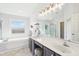 Bright bathroom with a dual sink vanity, an oversized mirror, a soaking tub, and tile flooring at 14936 Newport Dr, Westfield, IN 46074