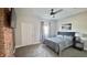 Bright bedroom featuring a queen bed, exposed brick accent wall, and modern ceiling fan at 1505 S Alabama St, Indianapolis, IN 46225