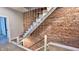 Modern staircase featuring wood treads, exposed brick, and minimalist railing at 1505 S Alabama St, Indianapolis, IN 46225