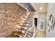 Open staircase with floating wooden treads, brick wall, and metal railing at 1505 S Alabama St, Indianapolis, IN 46225