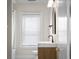 Modern bathroom with floating vanity, black hardware, and a window with blinds for natural light at 1714 Elm St, Columbus, IN 47201