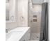 Bathroom features a tiled shower with built-in shelving, modern fixtures, and shower curtain at 1714 Elm St, Columbus, IN 47201