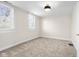 Bright bedroom featuring plush carpeting, two windows with white blinds, and neutral colored walls at 1714 Elm St, Columbus, IN 47201