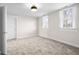 Bright bedroom featuring plush carpeting, two windows with white blinds, and neutral colored walls at 1714 Elm St, Columbus, IN 47201