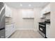 Functional kitchen featuring white cabinets, a black gas range, and tiled flooring at 1714 Elm St, Columbus, IN 47201