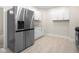 Open kitchen layout showcasing stainless steel refrigerator, tile floors, and white cabinets at 1714 Elm St, Columbus, IN 47201