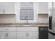 Close up shot of the kitchen sink, stainless steel appliances, white cabinets and a window at 1714 Elm St, Columbus, IN 47201