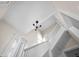 View looking up a staircase with a three light chandelier, neutral paint, and white trim at 1714 Elm St, Columbus, IN 47201