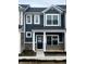 Charming two-story townhome with a covered porch, stone accents, and white framed windows at 19493 Grassy Branch Rd, Westfield, IN 46074