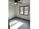 Bright bedroom featuring a ceiling fan, light gray flooring, neutral walls, and a large window with a view of the outdoors at 19533 Justin Morgan Dr, Westfield, IN 46074