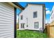 A backyard with a lush green lawn, newly installed AC unit, leading up to the white siding on the home at 35 N Keystone Ave, Indianapolis, IN 46201