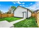 A detached shed in backyard offers extra storage space, white siding, dark trim, green grass, and wood fence at 35 N Keystone Ave, Indianapolis, IN 46201