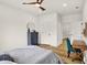 Brightly lit bedroom with wood-look floors, desk, and a dresser with round mirror and interesting ceiling fan at 35 N Keystone Ave, Indianapolis, IN 46201