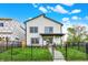 Charming two-story home with black trim, a well-manicured lawn, and a black metal fence at 35 N Keystone Ave, Indianapolis, IN 46201