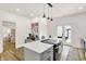 Modern kitchen featuring a large island with a cooktop, gray cabinets, and access to the backyard at 35 N Keystone Ave, Indianapolis, IN 46201