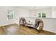 Well-lit loft with bright wood-look flooring, modern lighting, and two comfortable hanging papasan chairs at 35 N Keystone Ave, Indianapolis, IN 46201