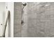 Close-up of elegant marble tiled shower featuring modern fixtures and hardware at 35 N Keystone Ave, Indianapolis, IN 46201