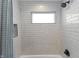 Featuring modern fixtures, enjoy this shower with gray tiling and a window for natural light at 418 Sanders St, Indianapolis, IN 46225