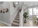 Carpeted staircase with a white railing, modern wall decor, and natural light from nearby windows at 418 Sanders St, Indianapolis, IN 46225