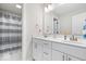 Bright bathroom featuring a double vanity, marble countertop, and a shower with stylish patterned curtain at 4544 W Rising Sun Dr, New Palestine, IN 46163