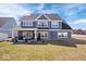 Stunning exterior view of a well-maintained home with a spacious backyard and covered patio area at 4544 W Rising Sun Dr, New Palestine, IN 46163