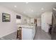 Spacious kitchen featuring a center island, white cabinetry, modern appliances, and a view into the bedroom at 4629 Indianola Ave, Indianapolis, IN 46205