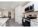 Well-equipped kitchen with stainless steel appliances, granite countertops, and a view of the dining and bedroom at 4629 Indianola Ave, Indianapolis, IN 46205