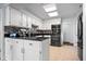 Bright kitchen features white cabinets, black countertops, tile backsplash, and stainless steel appliances at 504 Bent Tree Ln, Indianapolis, IN 46260