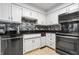 Well-lit kitchen features white cabinets, modern appliances, black countertops and stylish tile backsplash at 504 Bent Tree Ln, Indianapolis, IN 46260