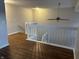 Upstairs loft featuring white railings and laminate flooring that overlooks the living space below at 504 Elkhart Dr, Westfield, IN 46074