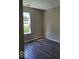 A bright bedroom featuring hardwood floors and a window providing natural light at 5822 Blackley Ln, Indianapolis, IN 46254