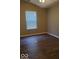 A simple bedroom with vinyl floors and natural light from a large window at 5822 Blackley Ln, Indianapolis, IN 46254