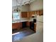 Kitchen with wood cabinets, black appliances, and vinyl floors at 5822 Blackley Ln, Indianapolis, IN 46254